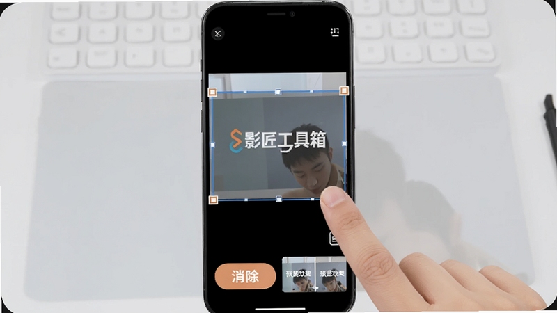 影匠工具箱去水印功能演示画面,手机屏幕中显示视频画面与水印框选区域,手指正在拖动选框,屏幕下方有消除按钮与预览效果对比,背景为浅灰色操作台风格,适配Boogu模型生成