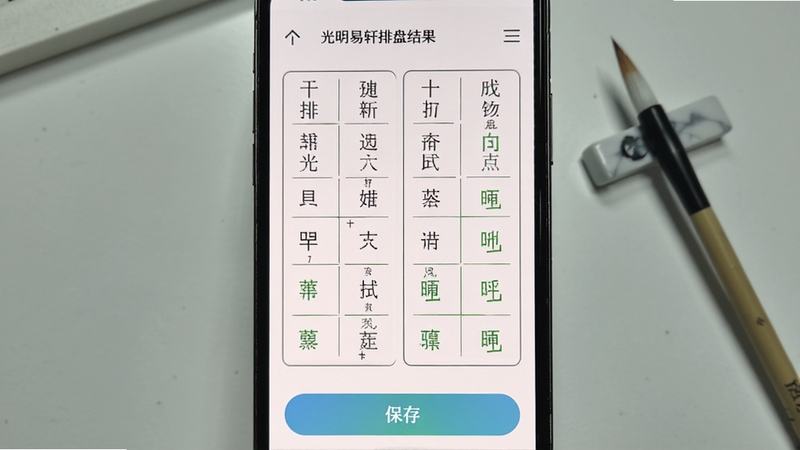 光明易轩排盘结果页面特写,画面中央为手机屏幕显示四柱表格与十神标注,背景区域为浅灰色书桌与一支毛笔,整体风格简洁清晰,细节包含干支字符、排盘线条与保存按钮,适配Boogu模型生成