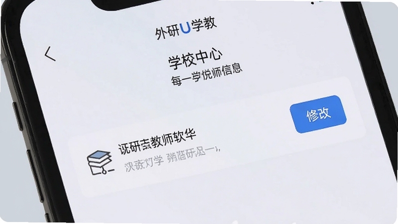 手机屏幕特写,显示外研U学教师软件的个人中心页面,学校信息一栏旁有修改按钮,界面简洁,背景为柔和的浅灰色,突出操作便捷性。