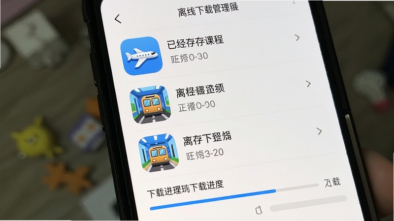 轻松说霸 离线下载管理页面 手机屏幕显示已缓存课程列表与下载进度条 图标包含飞机地铁场景 Boogu模型生成 简洁实用风格