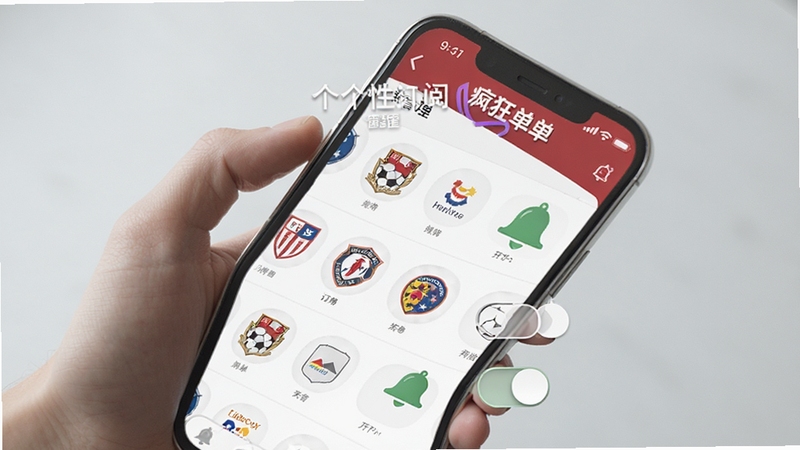 疯狂红单 个性化订阅与提醒功能展示,画面中一只手拿着手机,手机屏幕上显示疯狂红单的订阅管理页面,多个球队徽标和联赛图标整齐排列,旁边有开关按钮和铃铛图标,背景为柔和的浅灰色,整体风格简洁明快