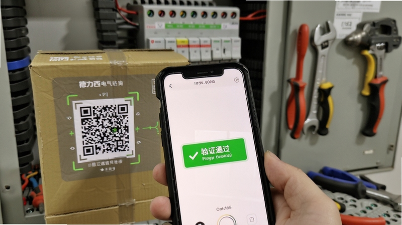 德力西电气防伪查询功能展示,手机摄像头对准产品包装二维码,屏幕显示验证通过绿色提示,背景为配电箱与工具