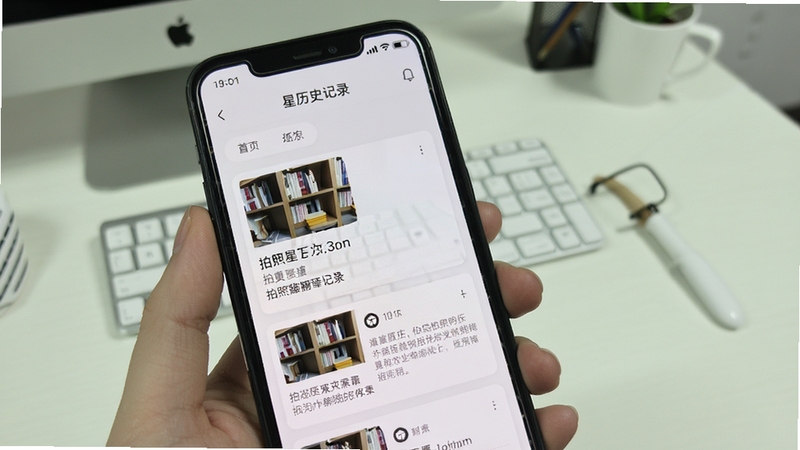 拍照翻译星历史记录页面展示,手机屏幕中呈现按时间排列的翻译记录卡片,每张卡片包含缩略图、原文摘要与译文预览,界面采用卡片式布局,配色为白色与浅灰色搭配,背景为简洁的办公桌面环境,体现软件拍照翻译星的记录留存功能