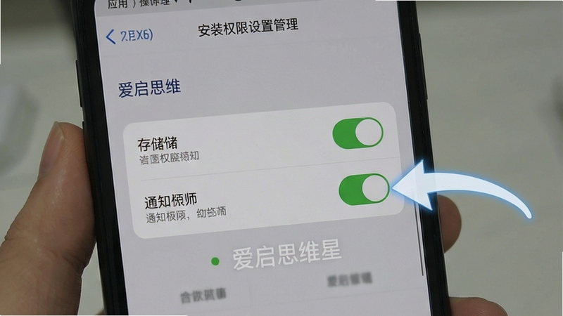 爱启思维星安装权限设置示意场景,手机屏幕显示应用权限管理页面,存储与通知权限开关处于开启状态,背景为简洁的灰色设置界面,画面突出操作指引感