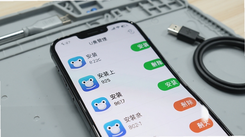 U鱼安装包管理界面特写,手机屏幕显示安装包列表,每个条目包含应用图标、名称、版本号与文件大小,右侧有安装与删除按钮,背景为淡灰色工作台场景,桌面摆放着手机与数据线,光线柔和,突出U鱼管理功能的整洁与高效