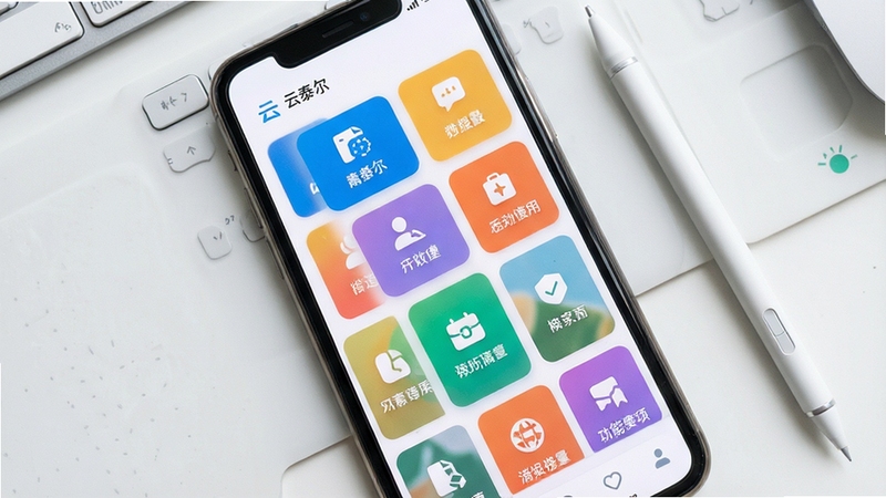 画面展示云泰尔应用首页功能模块聚合布局,多个彩色功能卡片整齐排列在手机屏幕上,卡片带有简洁图标与文字标签,背景为浅灰白色工作台场景,旁边放置一支触控笔,整体风格清新明快,俯视视角,细节清晰