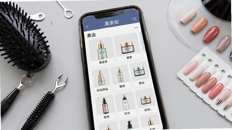 美条街应用界面特写,屏幕中呈现美业商品分类网格与护肤瓶罐缩略图,旁边摆放美发工具与美甲色卡,浅灰桌面背景,俯视视角,画面干净整洁,突出供应链选品场景