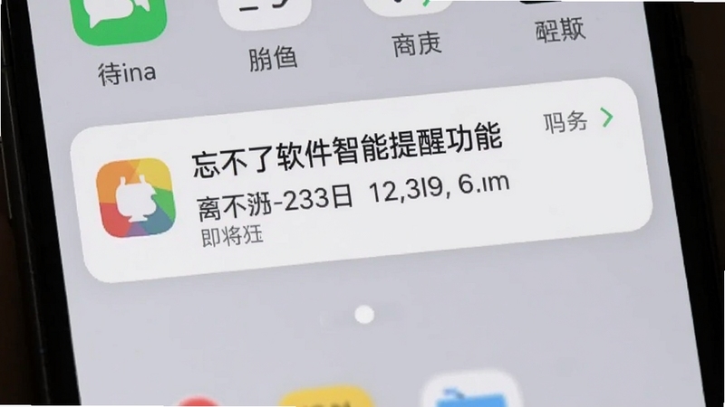 忘不了软件智能提醒功能截图,手机屏幕上显示一条即将到期的纪念日提醒通知,背景为浅灰色桌面,通知卡片带有彩色图标和文字,界面简洁醒目