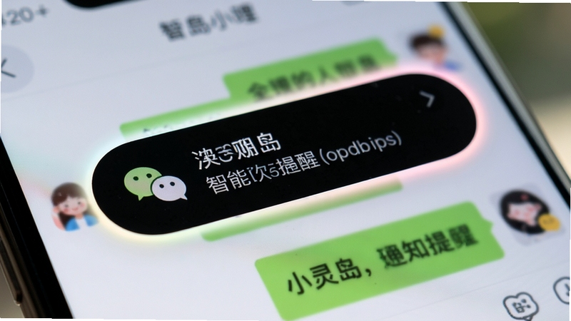 小灵岛智能通知提醒功能特写,手机屏幕顶部黑色胶囊区域弹出微信消息提醒,胶囊边缘有柔和的彩色光晕,背景是模糊的聊天界面,画面聚焦于通知弹窗的细节,风格写实,光线自然