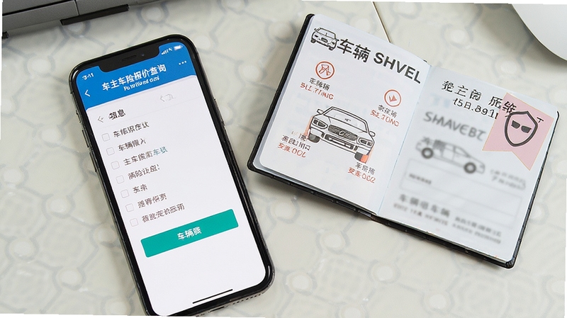 一张俯拍照片,手机屏幕停留在车主车险报价查询的车辆信息录入页面,手机旁边放着一本打开的车辆行驶证,背景是整洁的办公桌面,画面清晰,强调信息录入的准确性与安全性