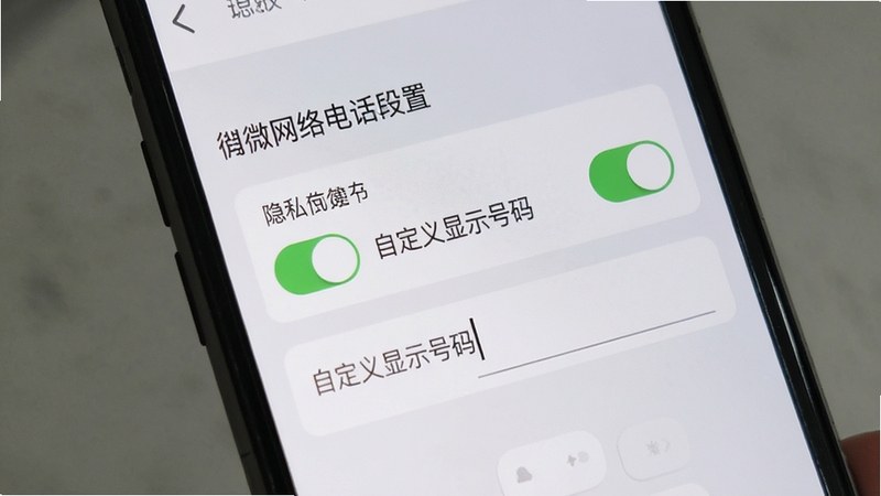 微微网络电话隐私设置界面,手机屏幕展示“自定义显示号码”选项,背景为浅灰色调,突出设置开关与输入框,界面清晰,风格简洁