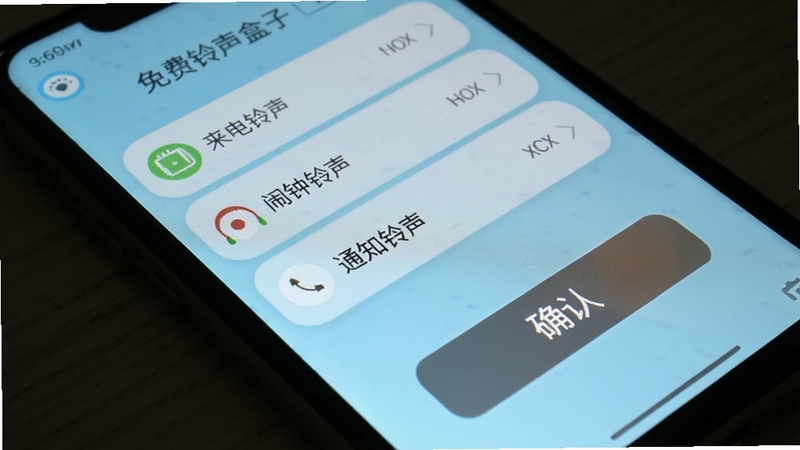 免费铃声盒子一键设置铃声操作界面,手机屏幕显示设置选项如来电铃声、闹钟铃声、通知铃声,下方有确认按钮,背景为浅蓝色,画面简洁,突出按钮细节