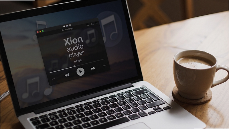 笔记本电脑键盘特写,屏幕上显示着Xion audio player的迷你播放模式界面,旁边有一杯咖啡,营造出轻松愉悦的听歌氛围,画面温馨写实,强调软件的便捷操控性,Xion audio player 预览图