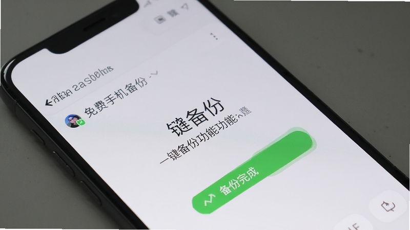 微聊天记录免费手机备份一键备份功能界面,手机屏幕显示备份完成状态,背景为浅灰色,画面简洁明了
