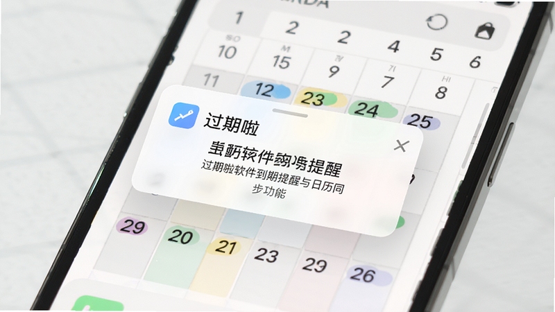 过期啦软件到期提醒与日历同步功能展示图,画面展示手机主屏幕弹出精致提醒卡片,背景是日历应用界面,有多个带颜色标记的日期点,风格写实明亮,突出提醒的及时性与重要性。