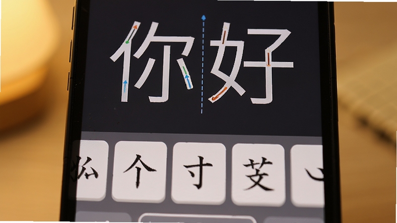 正宗笔画输入法笔画键盘特写,屏幕上半部分显示“你好”两字的笔画输入过程,下半部分为五个基本笔画按键特写,配以柔和暖色背景,突出软件教学引导功能和清晰键位布局