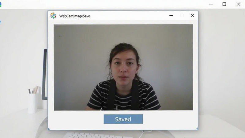 WebCamImageSave 软件主界面截图,居中展示摄像头实时预览窗口与保存按钮,背景为浅灰色简洁桌面环境,画面明亮清晰,突出软件功能区域