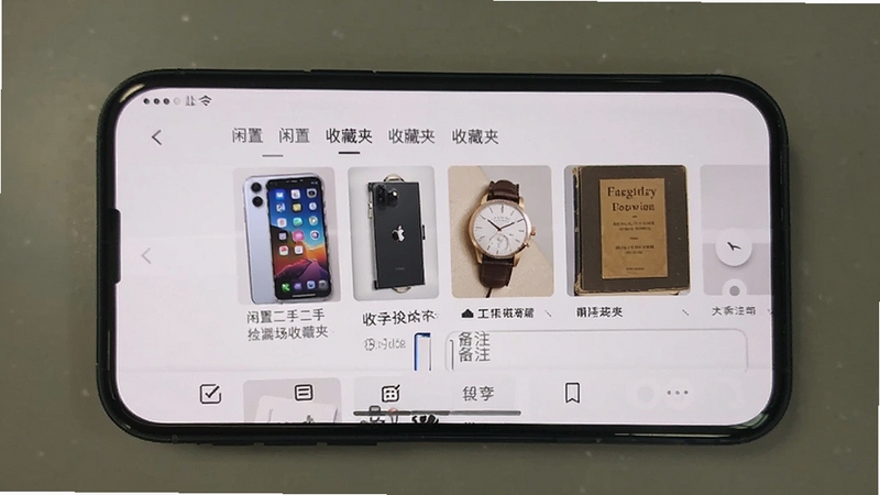 闲置二手捡漏市场收藏夹功能展示,手机屏幕显示多个已收藏的二手商品缩略图,包括二手手机、二手手表、二手书籍,界面有分类标签和备注输入框,背景简洁,突出整理与对比功能