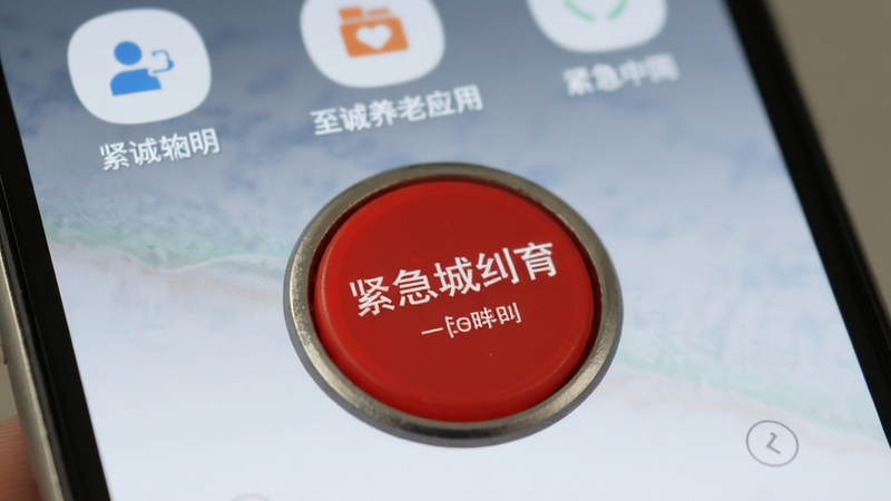 至诚养老应用紧急呼叫按钮特写,红色醒目按钮位于屏幕中央,背景为手机界面其他功能图标,整体设计简洁,突出安全功能