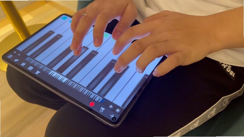 不同年龄层用户在平板上使用钢琴键盘Piano Keyboard进行演奏
